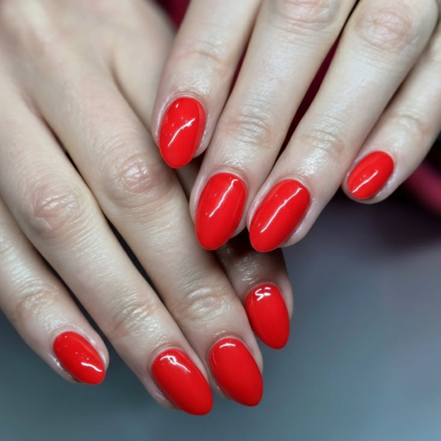 Glossy red almond gel manicure created at Studio J, Swords